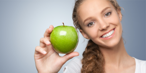 girl smiling holding apple