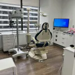 A dental chair and monitor in an examination room.