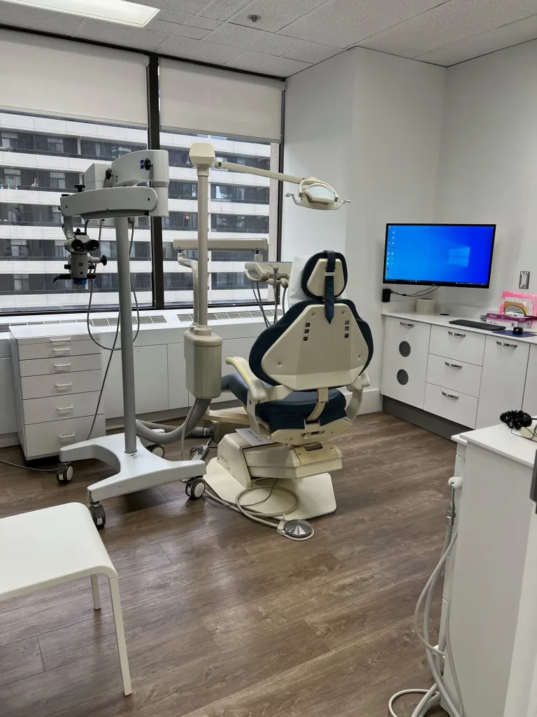 A dental chair and monitor in an examination room.