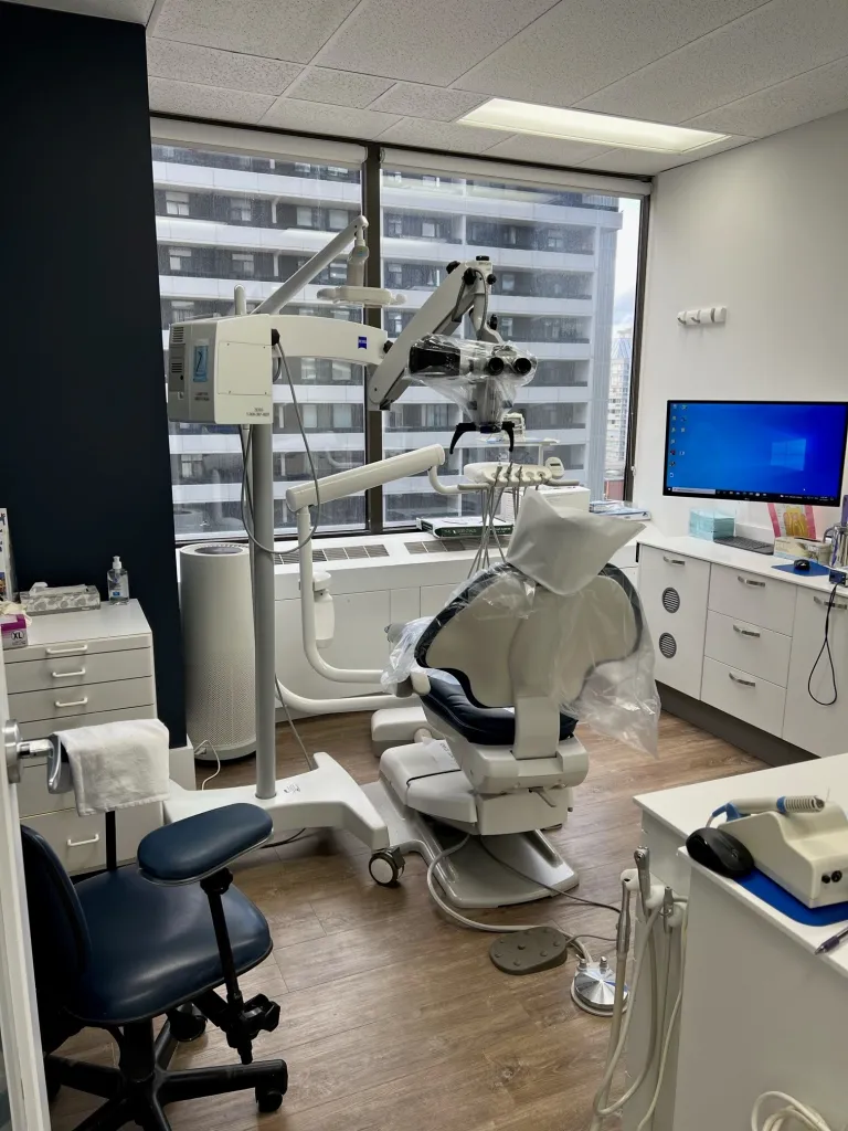 Dental chair, equipment, and a monitor in an examination room.